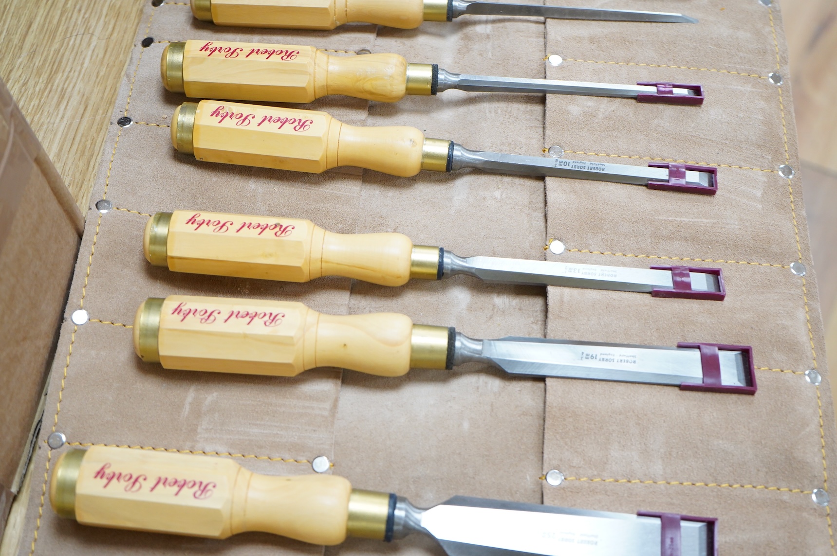 Two sets of Robert Sorby woodworking chisels, both in Kuny’s of Canada leather tool rolls; a nine piece set with octagonal handles, together with a six piece set with rosewood handles